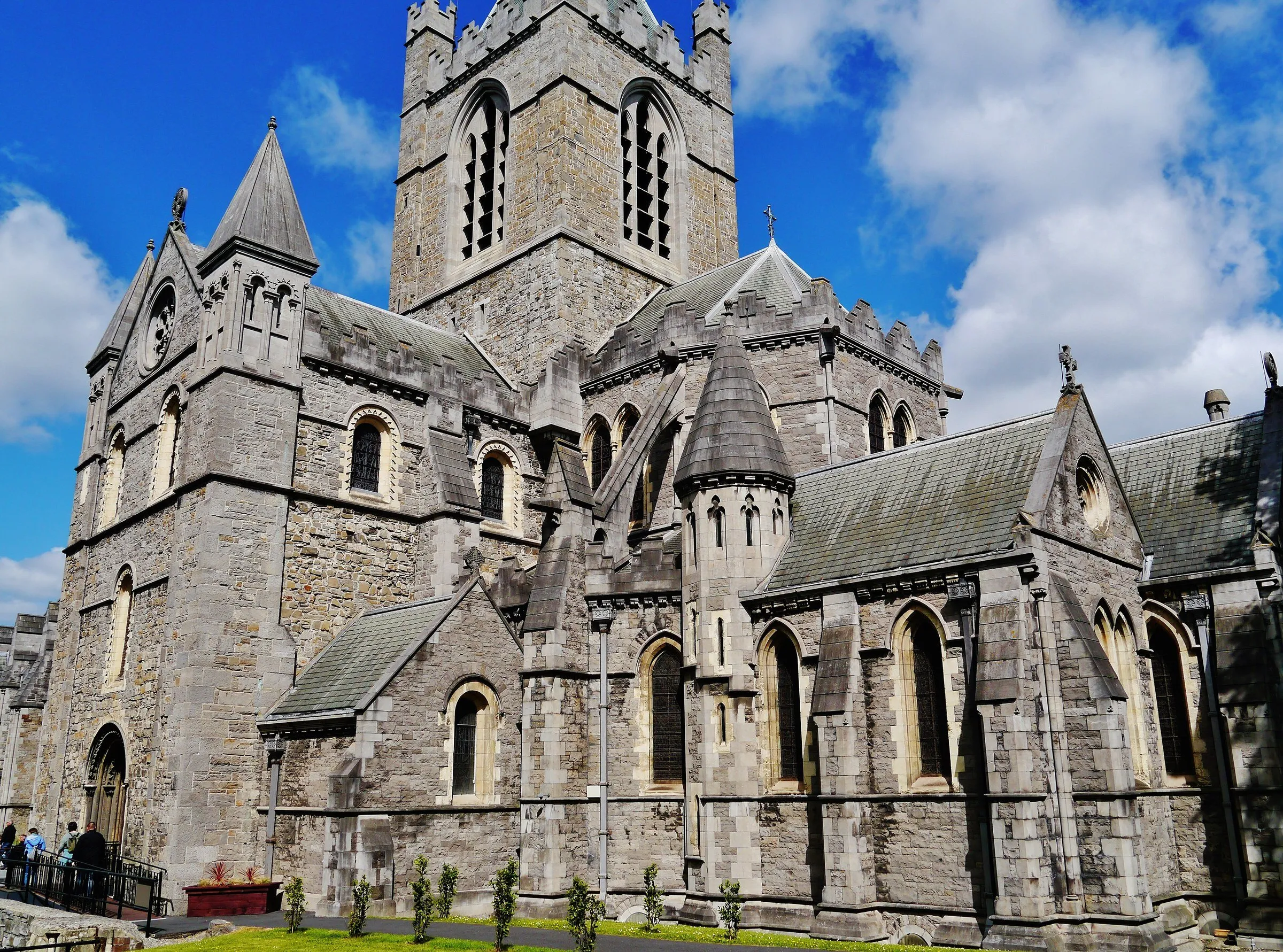 Detalle del exterior de Christ Church Cathedral, con ventanas ojivales, tejados de piedra y parte de la torre.