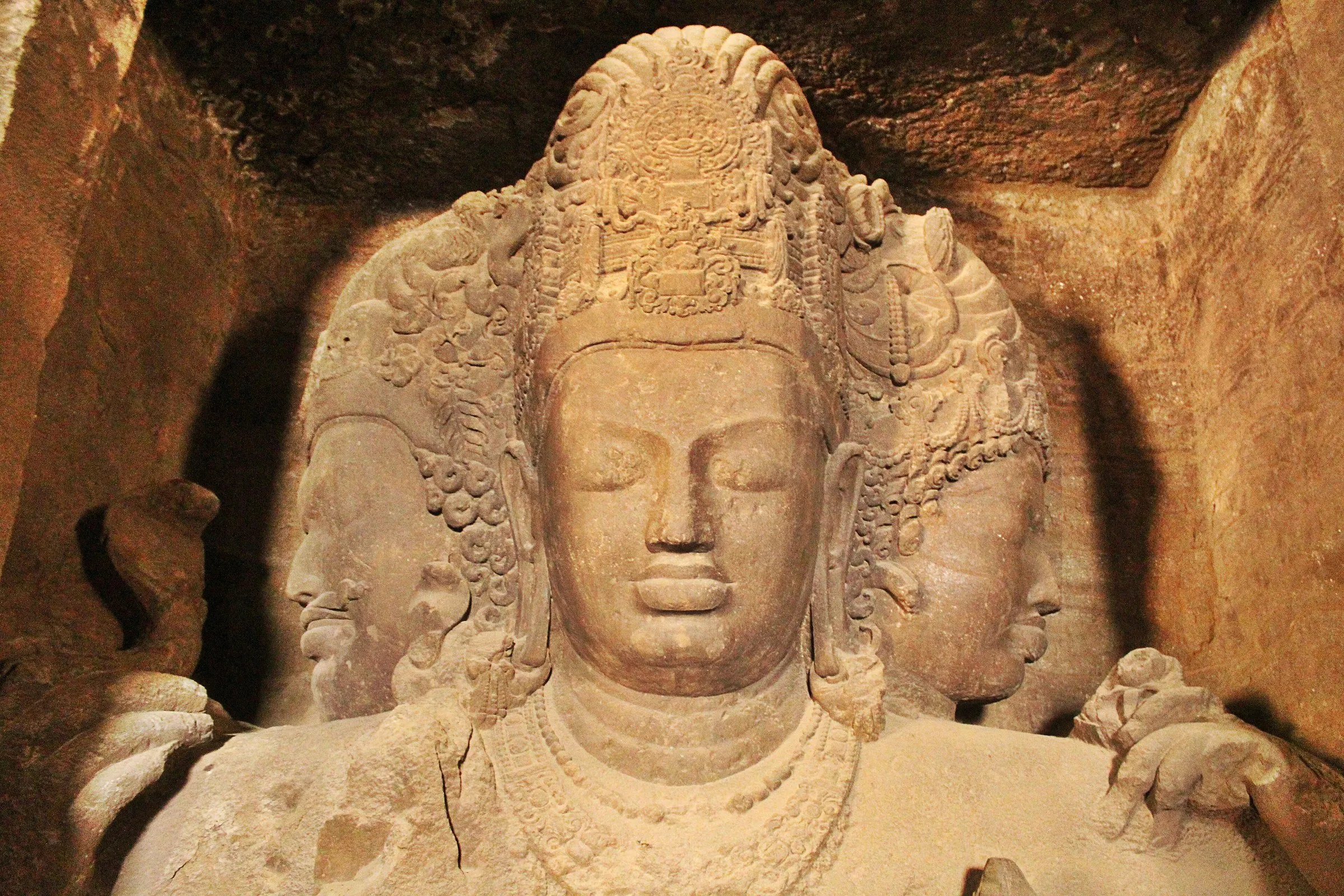 Close da escultura de três faces de Shiva (Trimurti) escavada na rocha da Caverna 1 das Cavernas de Elefanta, em Mumbai.