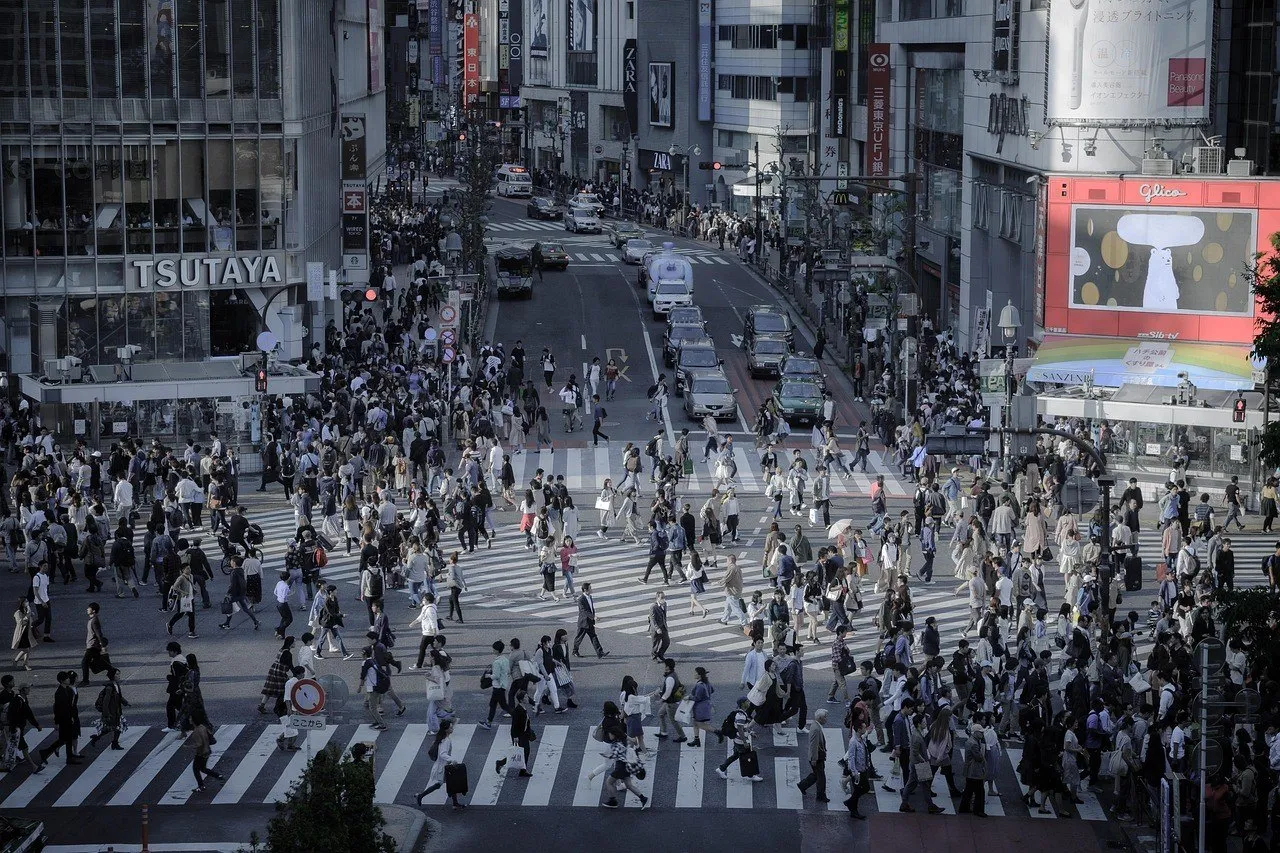 Cruce de Shibuya visto desde lo alto, con pasos diagonales, muchos peatones y fachadas comerciales.