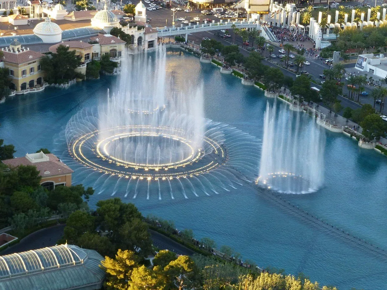 Water jets and lit circles on the Bellagio lake, seen from an elevated spot at dusk.
