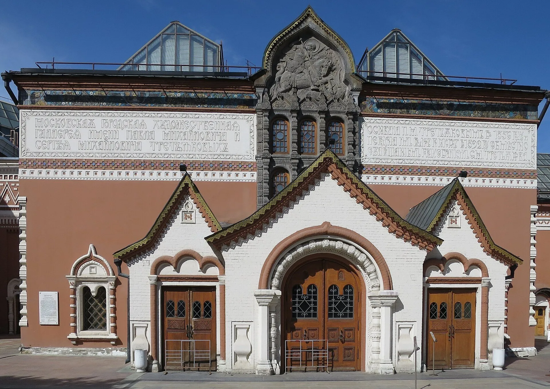 Fachada ornamentada de la Galería Tretiakov en Lavrushinsky, con puertas de madera, inscripciones y cielo azul.