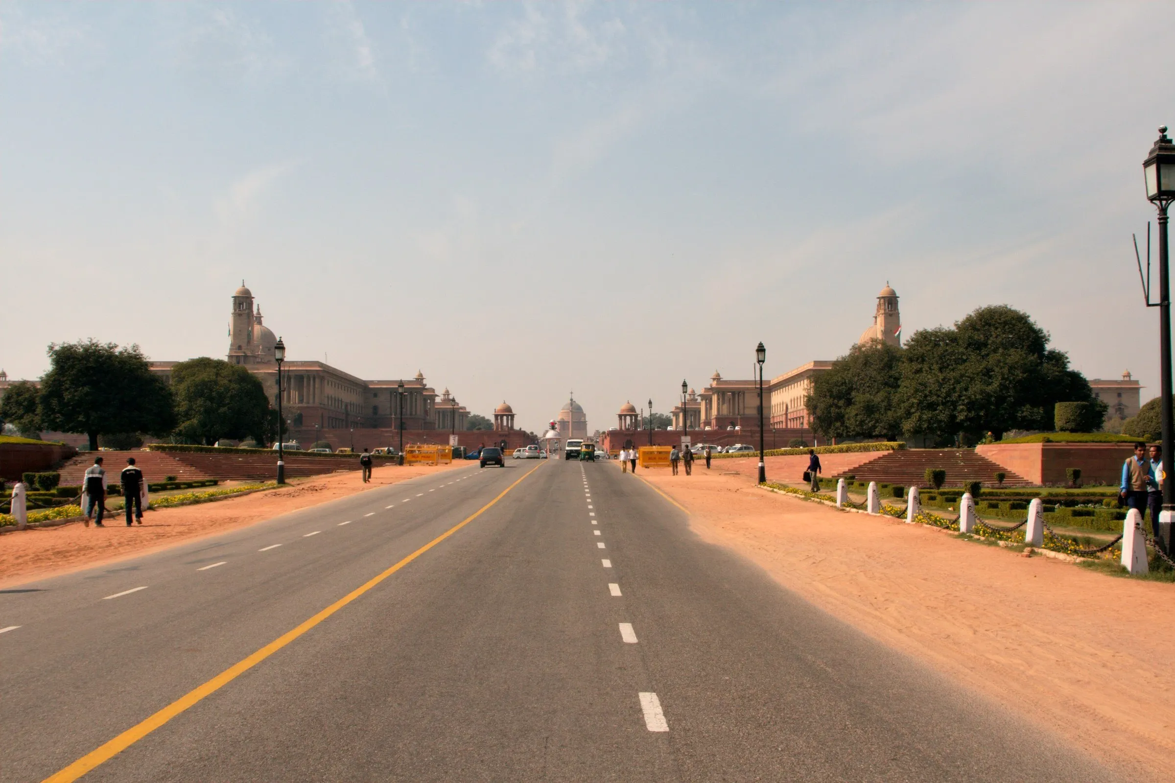 Avenida ancha y recta con edificios del Secretariado a ambos lados y la cúpula del Rashtrapati Bhavan al fondo.