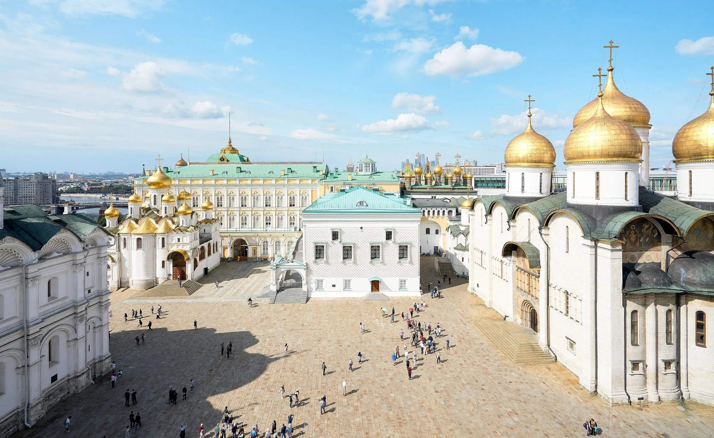 Vista elevada de la Plaza de las Catedrales en el Kremlin, con iglesias blancas, cúpulas doradas y visitantes.