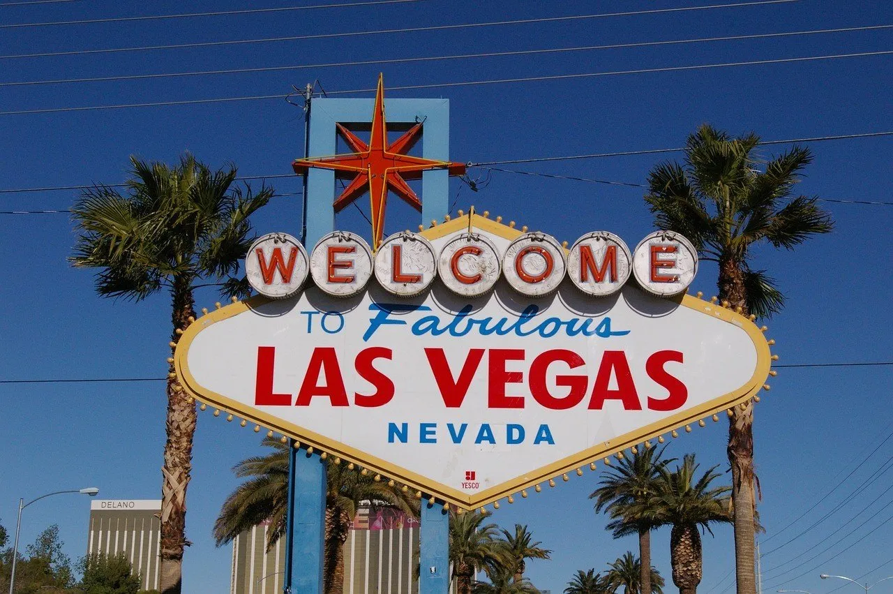 Full Welcome to Fabulous Las Vegas sign among palm trees under a blue sky.