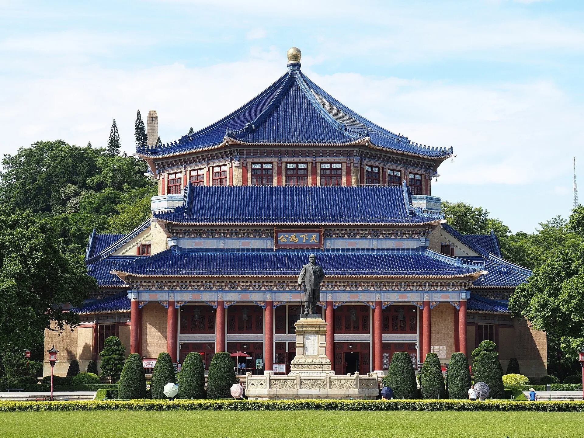 Memorial de Sun Yat-sen con tejados azules, columnas rojas, estatua central y césped al frente.