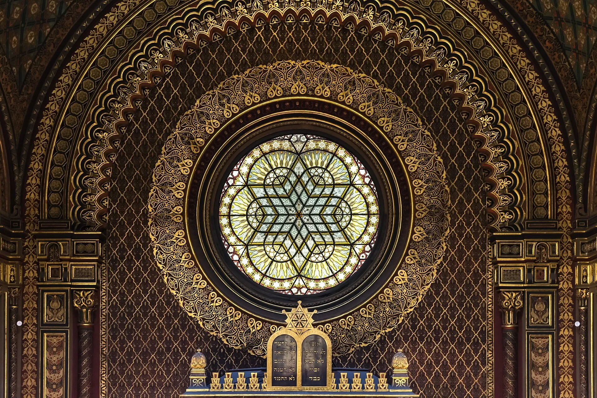 Vitral circular con estrella de David y ornamentación dorada en el interior de la Sinagoga Española de Praga.
