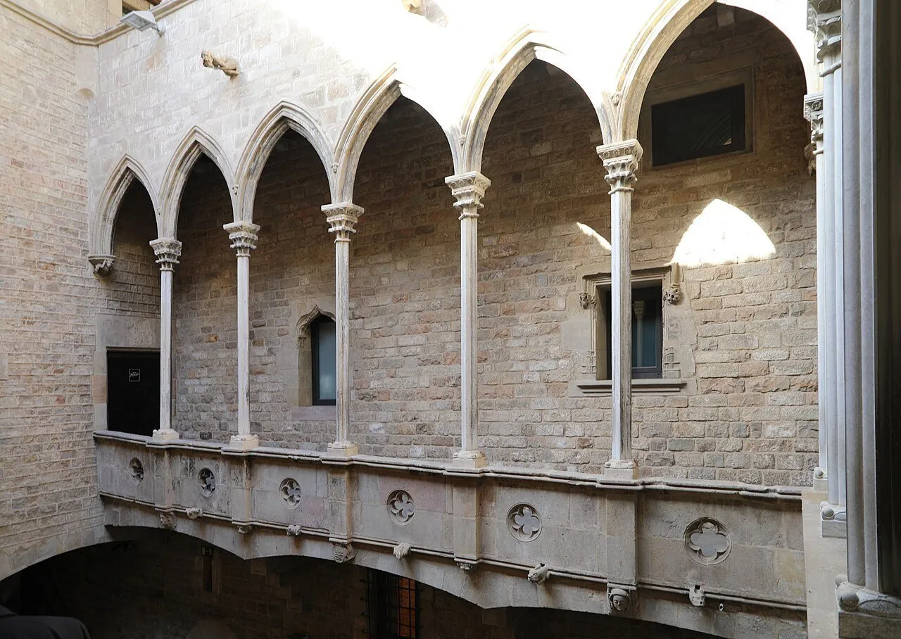 Galeria de arcos pontiagudos e colunas de pedra no pátio do Palau Aguilar, parte do Museu Picasso.