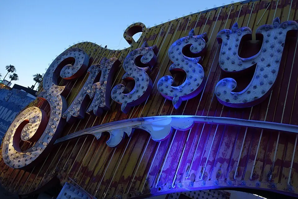 Old Sassy Sally’s sign letters in the Neon Boneyard, with blue lighting and a still-bright sky.