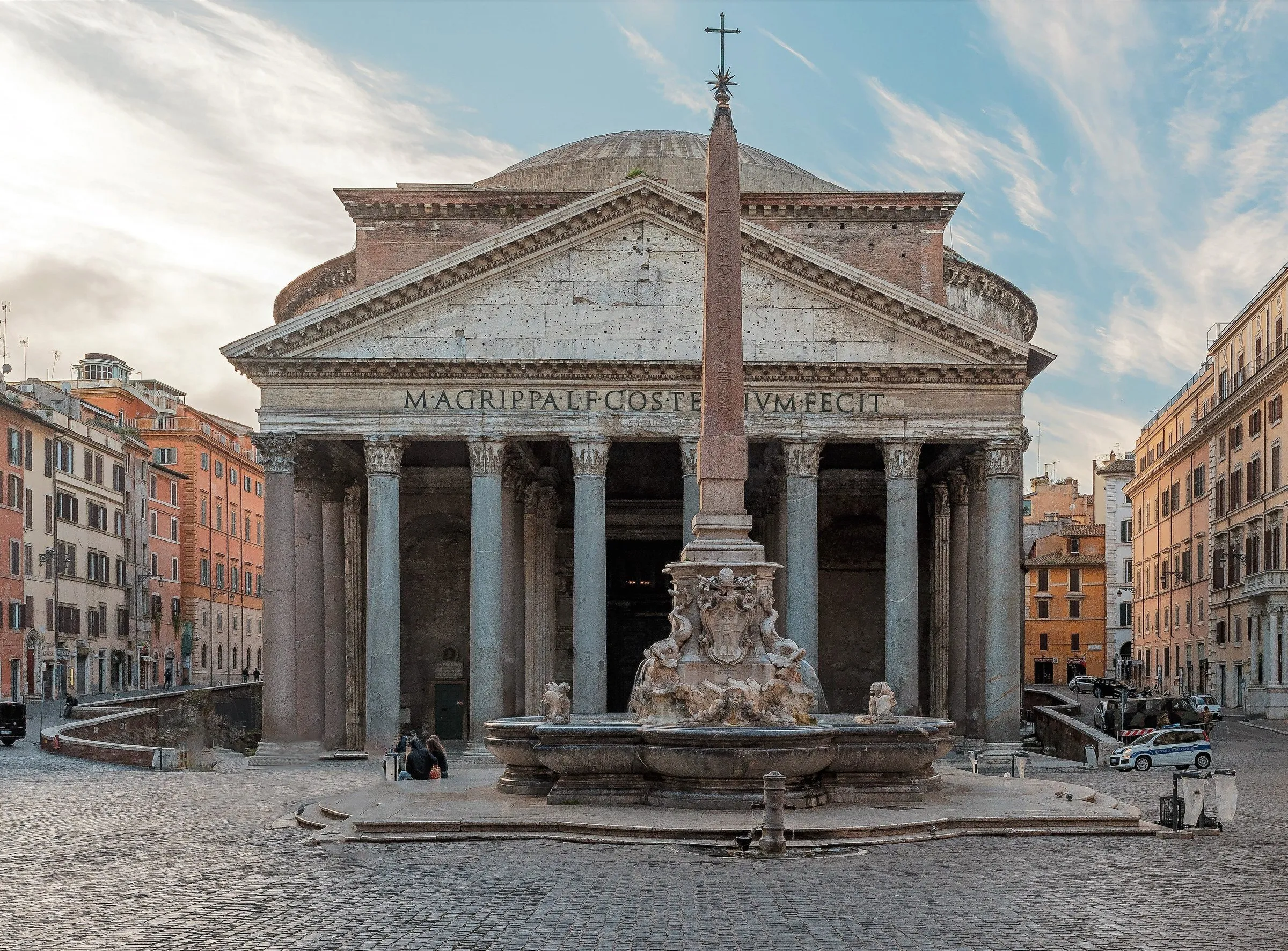 Facade of the Pantheon with columns and pediment, and the fountain with obelisk in the foreground in Piazza della Rotonda.