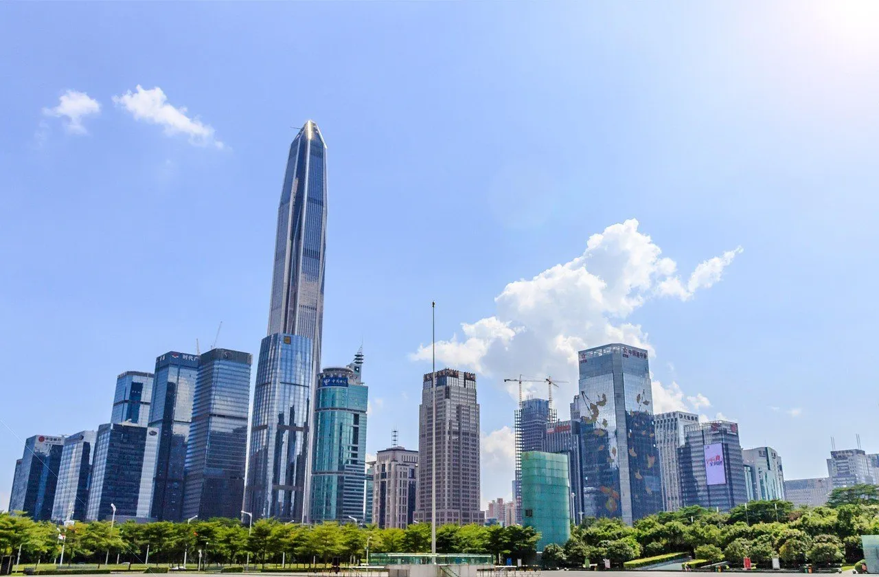 O Ping An Finance Center, torre esguia de vidro, entre outros arranha-céus de Futian sob céu azul.