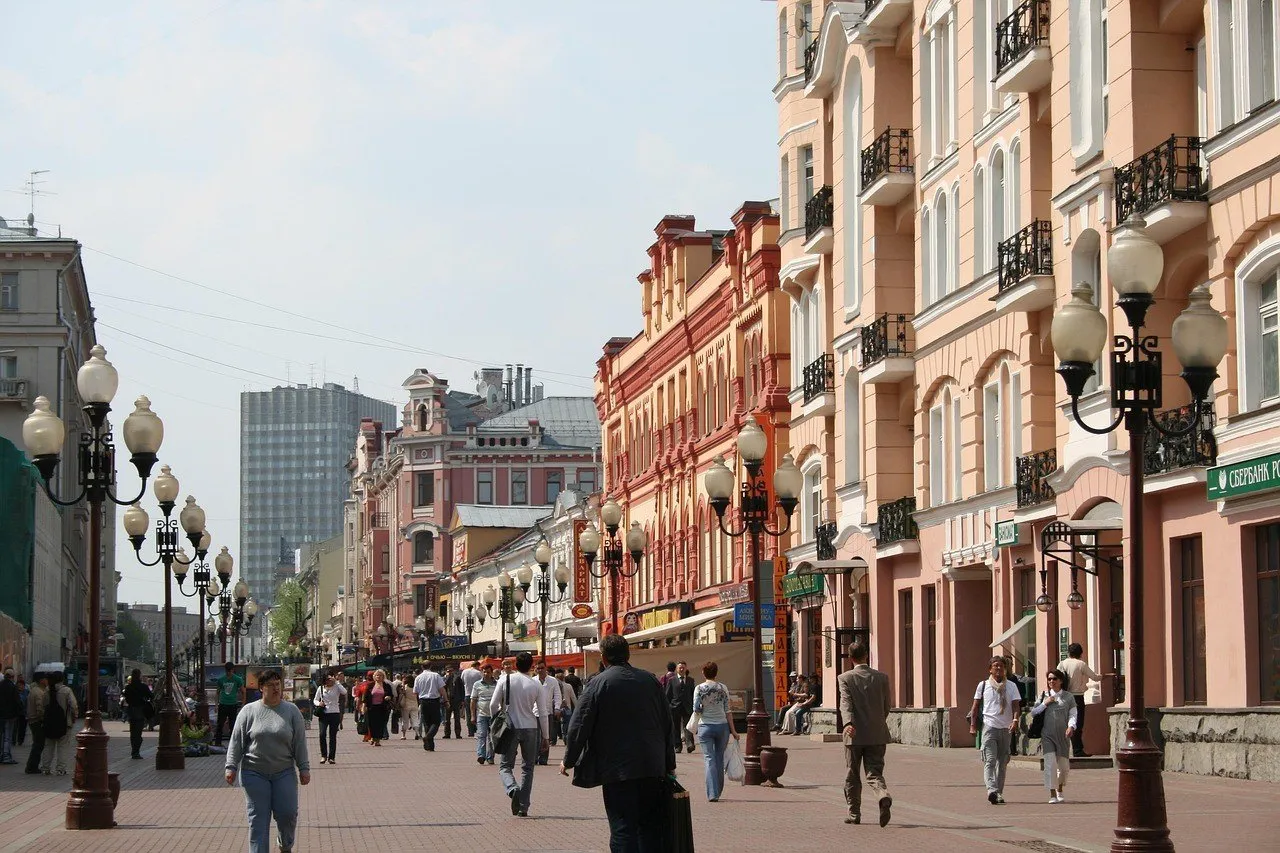 Calle peatonal Arbat, en Moscú, con fachadas de colores, farolas y gente caminando.