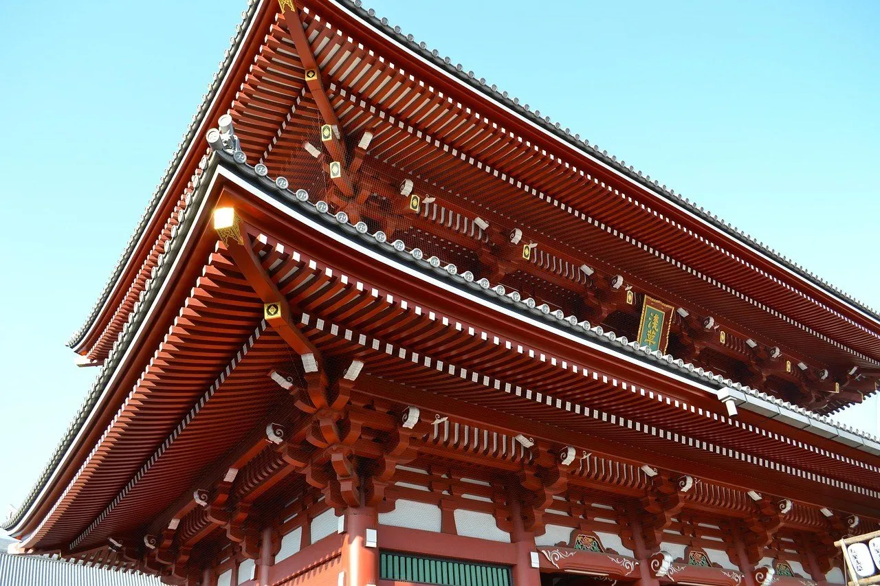 Aleros rojos en capas de la puerta Hozomon, en el templo Senso-ji, en Tokio, contra un cielo azul sin nubes.