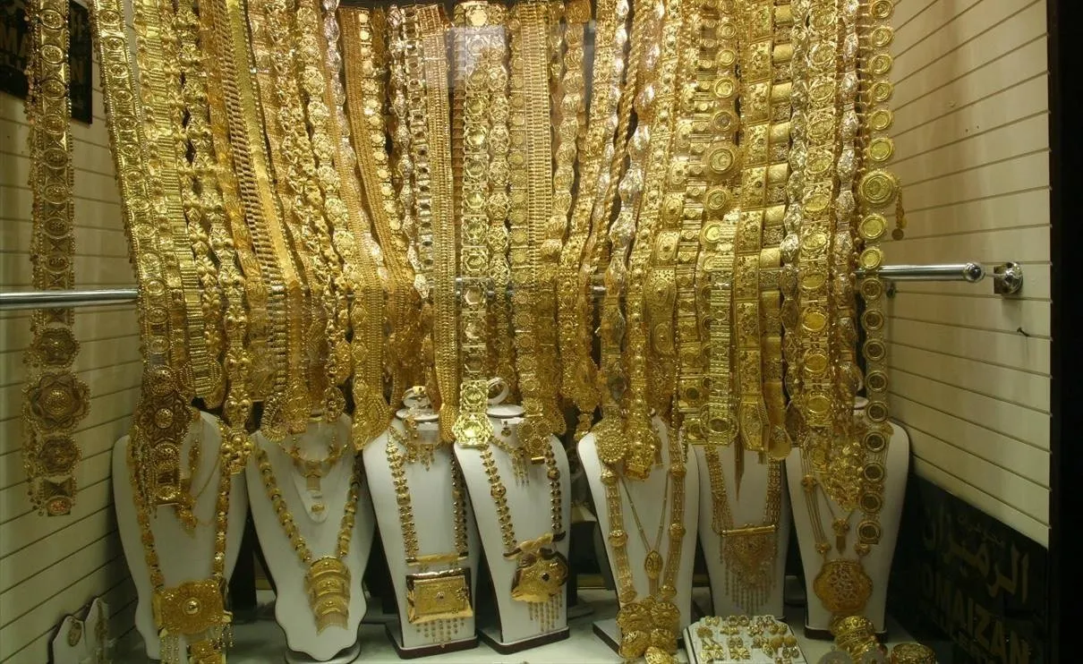 Gold Souk window in Deira with dozens of golden necklaces hanging and displayed on display busts.